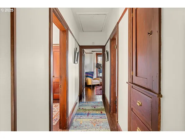 a view of a hallway with wooden floor and a living room