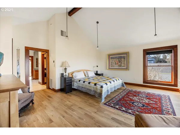 a bedroom with a bed and a painting on the wall