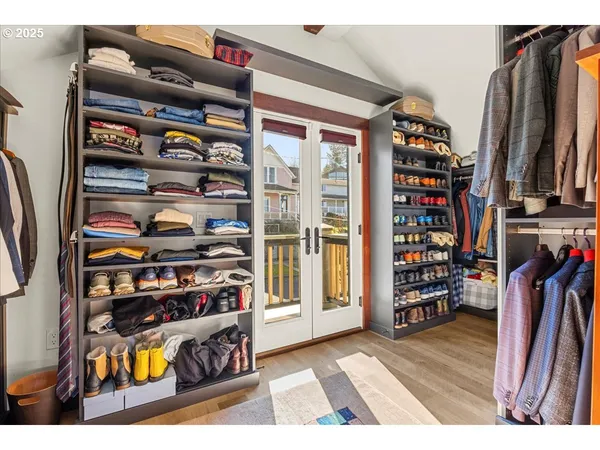 a view of walk in closet with clothes and shoes