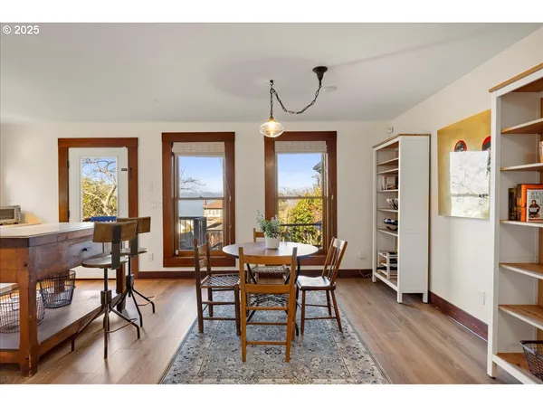 a dining room with wooden floor a chandelier a wooden table and chairs