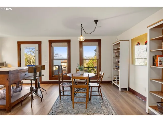 a dining room with wooden floor a chandelier a wooden table and chairs