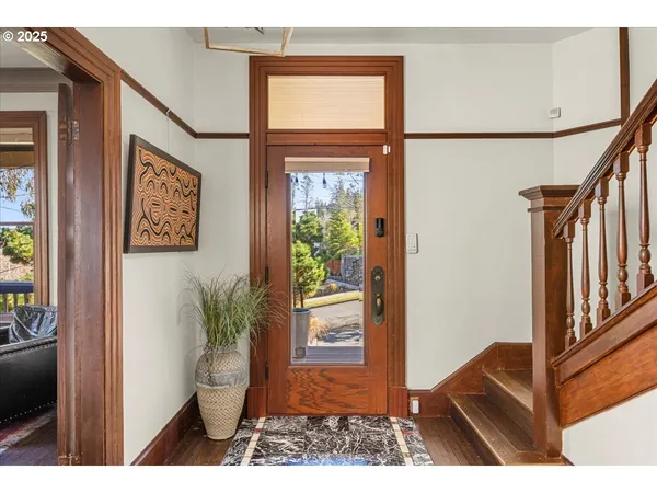 a view of a hallway with wooden floor and windows