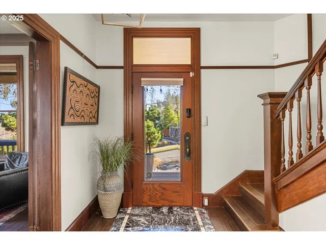 a view of a hallway with wooden floor and windows