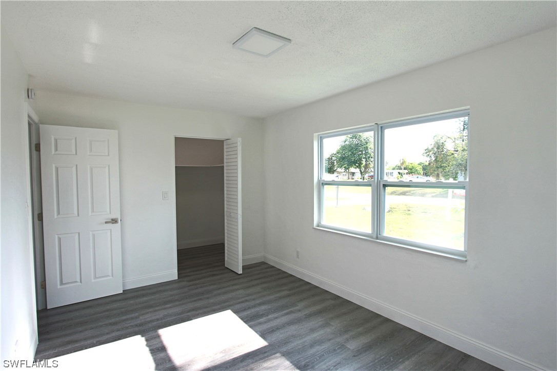 116 Oleander Road Lehigh Acres, FL 33936 - Photo 16 of 31 a view of an empty room with wooden floor and a window