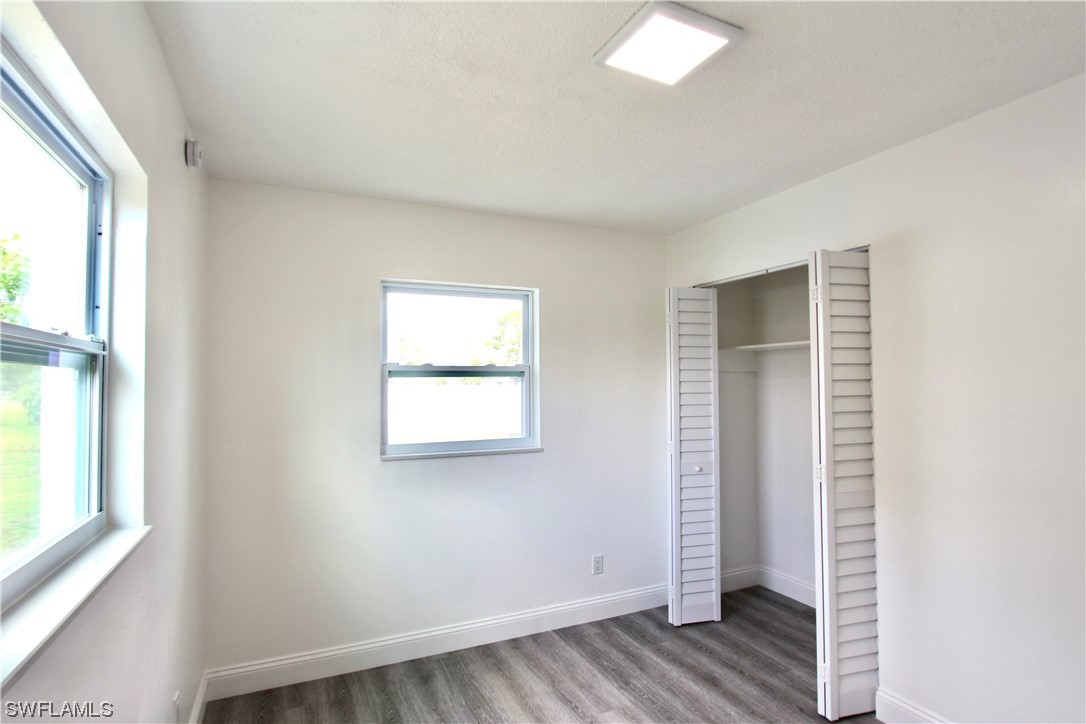 116 Oleander Road Lehigh Acres, FL 33936 - Photo 20 of 31 an empty room with wooden floor and windows