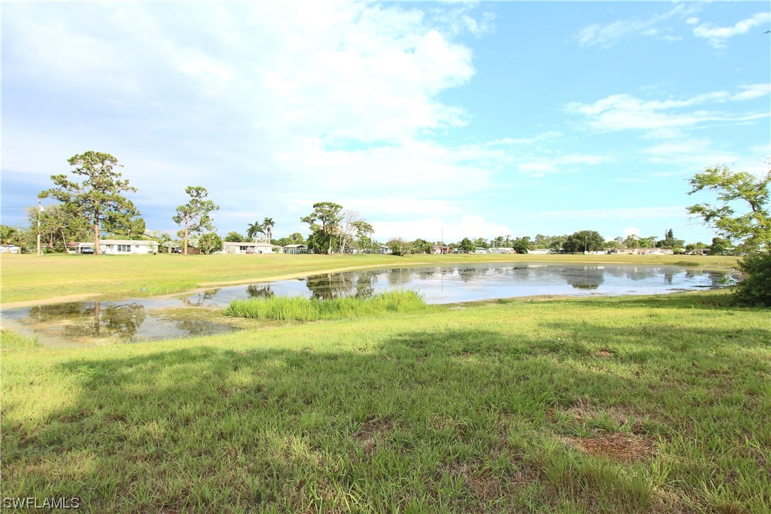 116 Oleander Road Lehigh Acres, FL 33936 - Photo 2 of 31 a view of a lake with houses in the back