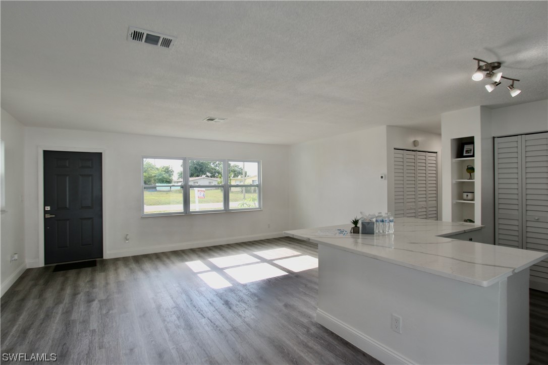 116 Oleander Road Lehigh Acres, FL 33936 - Photo 6 of 31 wooden floor in an empty room with a window