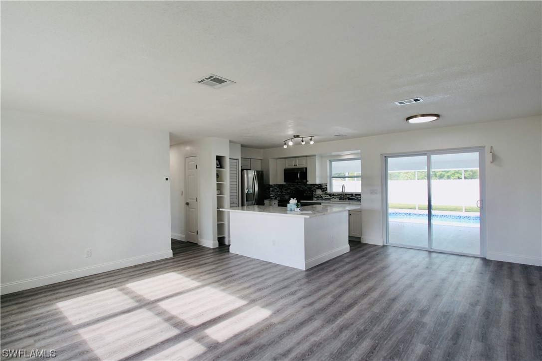 116 Oleander Road Lehigh Acres, FL 33936 - Photo 7 of 31 a kitchen with stainless steel appliances refrigerator and microwave