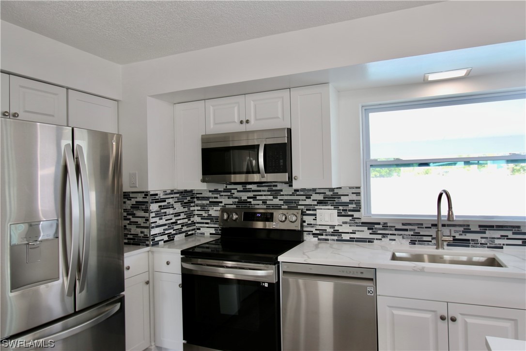 116 Oleander Road Lehigh Acres, FL 33936 - Photo 9 of 31 a kitchen with a sink stove and refrigerator