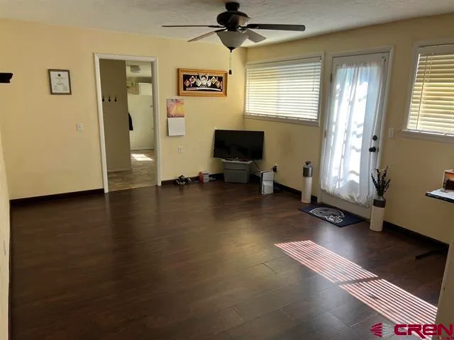 a view of a livingroom with workspace and a window