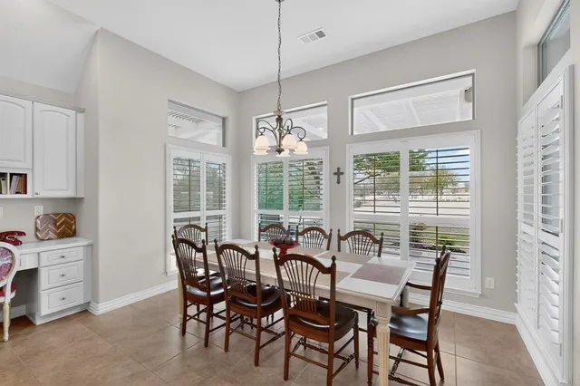 a kitchen with kitchen island a stove a table and chairs in it