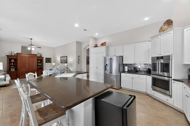 a kitchen with white cabinets and stainless steel appliances