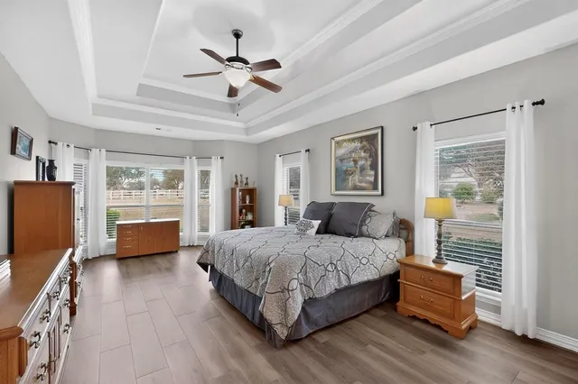 a spacious bedroom with a bed and wooden floor