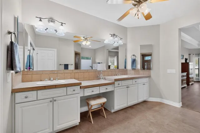 a spacious bathroom with a tub shower and mirror