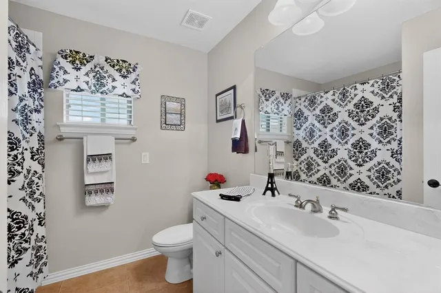 a kitchen with stainless steel appliances granite countertop a sink a refrigerator and white cabinets