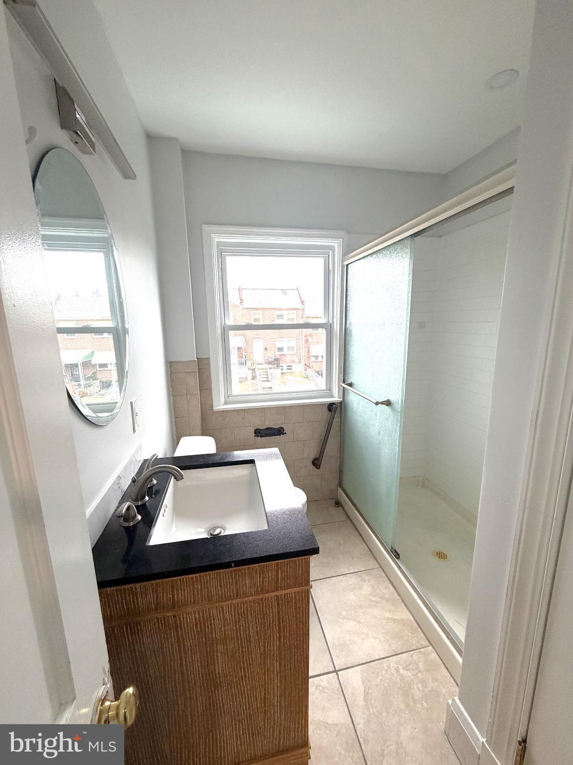 12 South Ellamont Street Baltimore, MD 21229 - Photo 15 of 26 a bathroom with a granite countertop sink a mirror and a shower