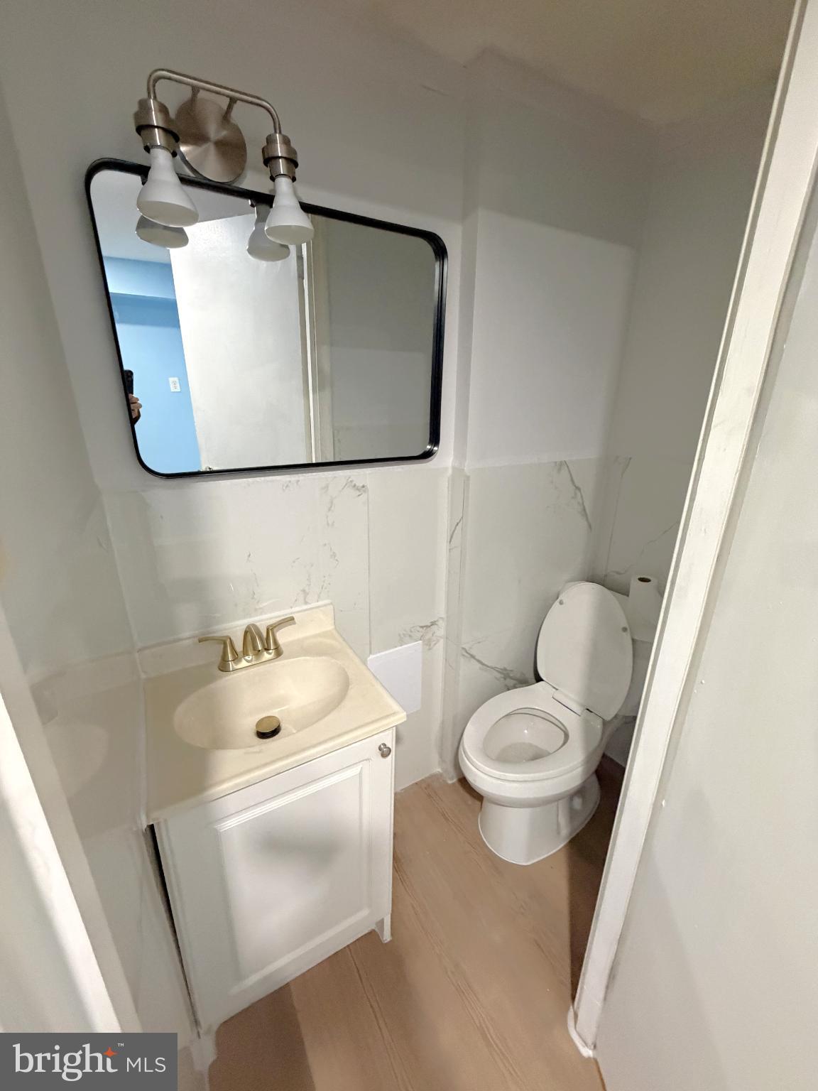 12 South Ellamont Street Baltimore, MD 21229 - Photo 17 of 26 a bathroom with a toilet sink and mirror