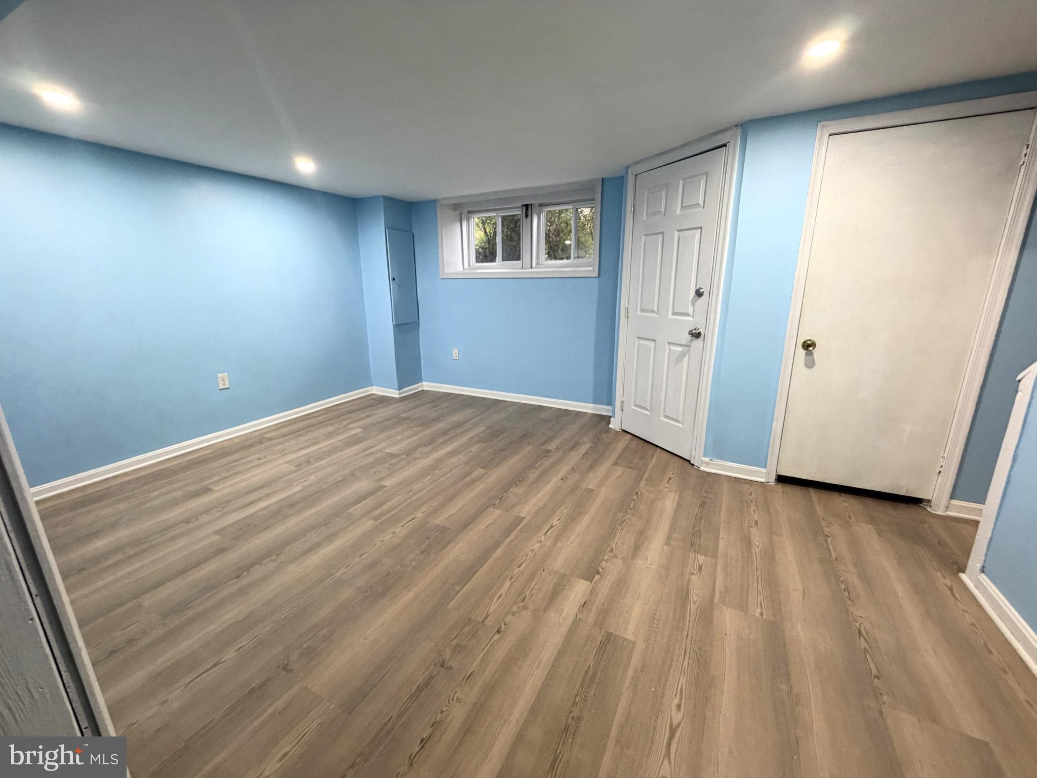 12 South Ellamont Street Baltimore, MD 21229 - Photo 18 of 26 a view of an empty room with wooden floor and a window