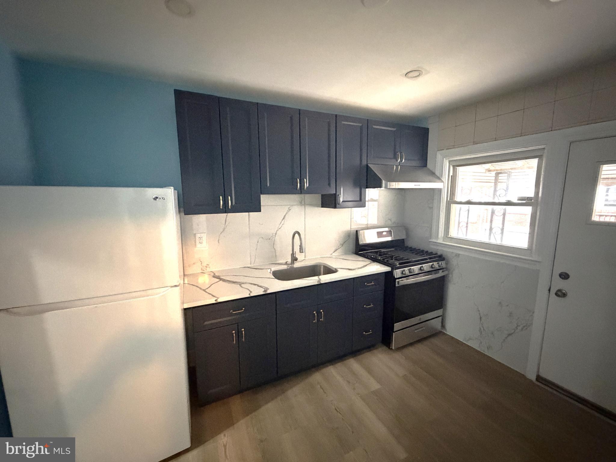 12 South Ellamont Street Baltimore, MD 21229 - Photo 2 of 26 a kitchen with granite countertop a refrigerator a sink dishwasher a stove and a refrigerator