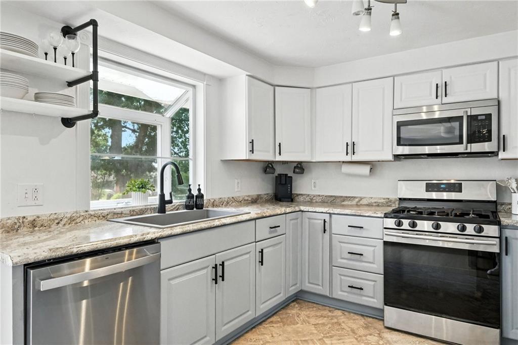 1335 Cardinal Drive Pittsburgh, PA 15243 - Photo 15 of 34 a kitchen with stainless steel appliances granite countertop a stove a sink and a microwave