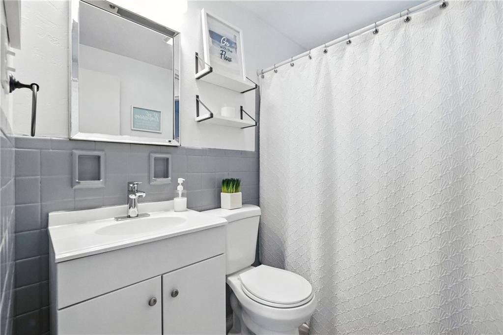 1335 Cardinal Drive Pittsburgh, PA 15243 - Photo 20 of 34 a bathroom with a sink a toilet and shower curtain