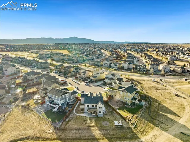 an aerial view of ocean and residential houses with outdoor space