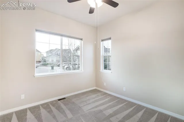 an empty room with chandelier fan