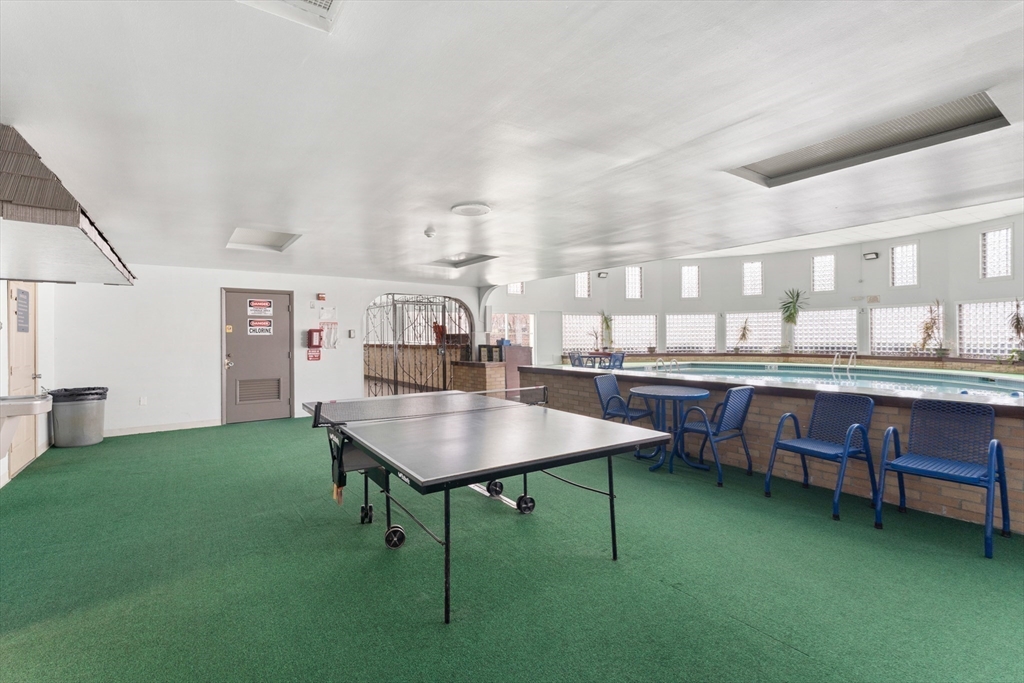 6 Shadowbrook Lane, Unit 9 Milford, MA 01757 - Photo 13 of 14 a room with kitchen island a table and chairs in it