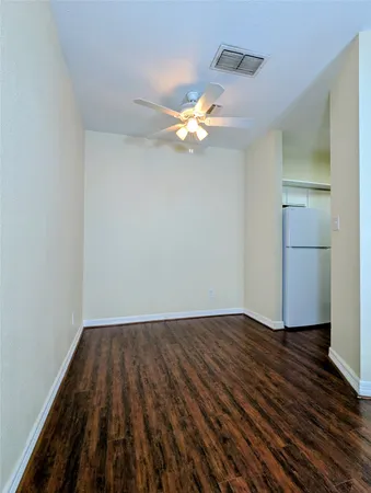 a view of a room with wooden floor and a fan