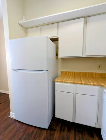 a utility room with wooden floor washer and dryer