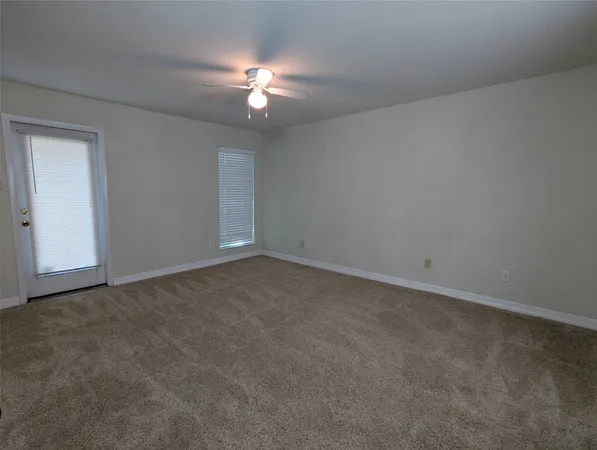 a view of an empty room with a chandelier fan