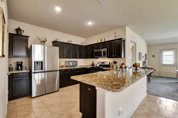 a kitchen with stainless steel appliances granite countertop a sink stove and refrigerator
