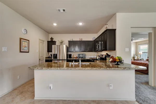 a kitchen with stainless steel appliances granite countertop a sink a stove and a refrigerator