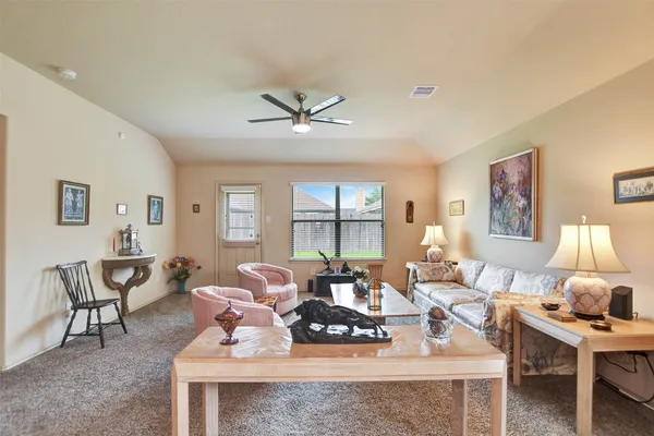 a living room with furniture a table and a large window
