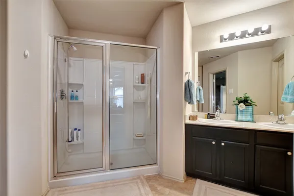 a bathroom with a double vanity sink mirror and shower