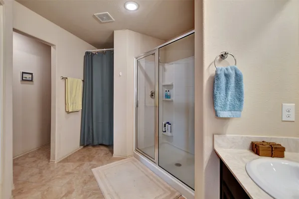 a bathroom with a shower sink and mirror