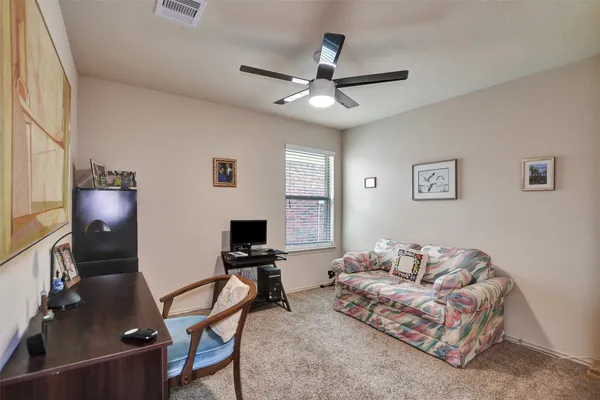 a livingroom with workspace couch and a window