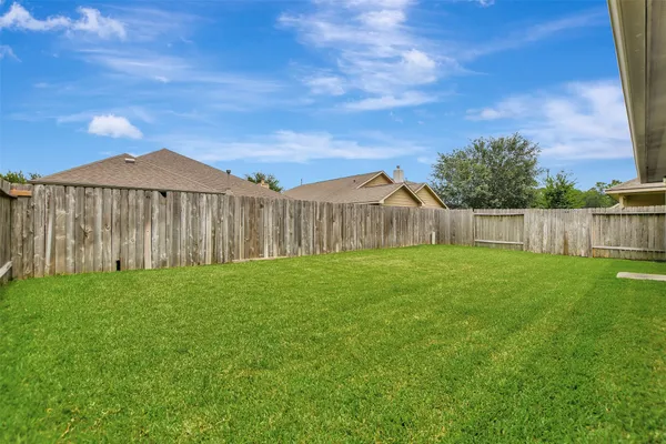 a view of a backyard with wooden fence