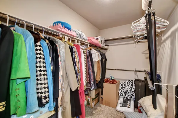 a view of walk in closet with clothes and shoes