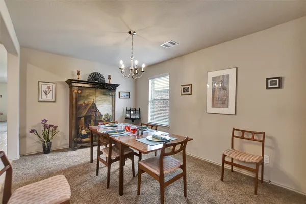 a view of a dining room with furniture and chandelier