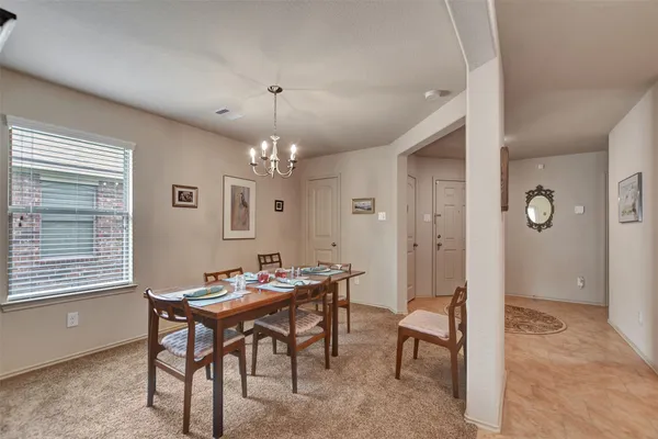 a view of a dining room with furniture and chandelier