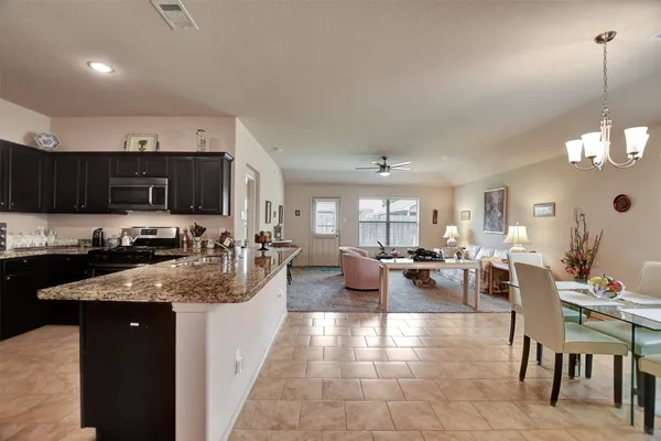 a large white kitchen with lots of counter space a sink appliances and cabinets