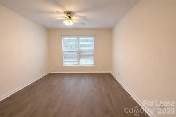 an empty room with a window and a ceiling fan