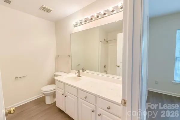 a bathroom with a sink a toilet and a mirror