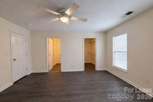 an empty room with wooden floor and window