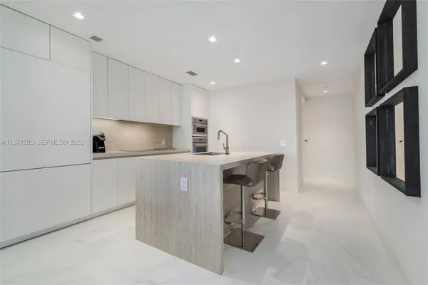 a kitchen with refrigerator and chairs