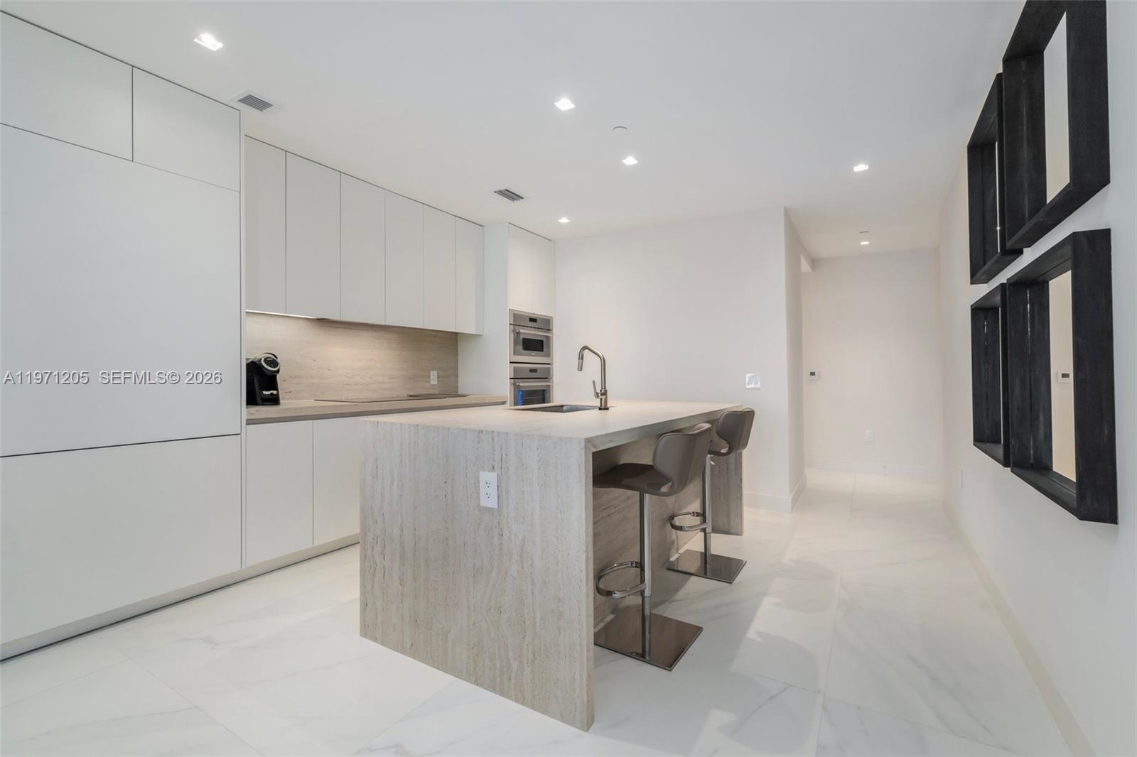700 Northeast 24th Street, Unit 2505 Miami, FL 33137 - Photo 13 of 19 a kitchen with refrigerator and chairs