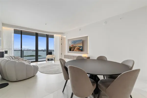 a view of a dining room with furniture and a large window