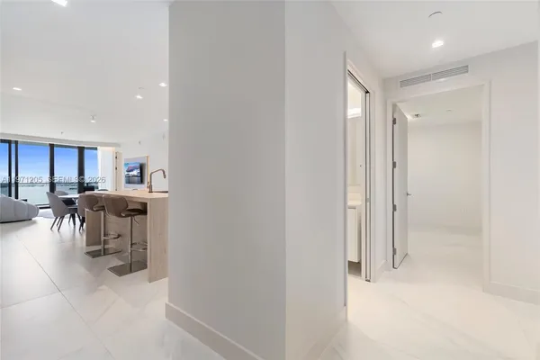 a view of a hallway with dining area and chandelier