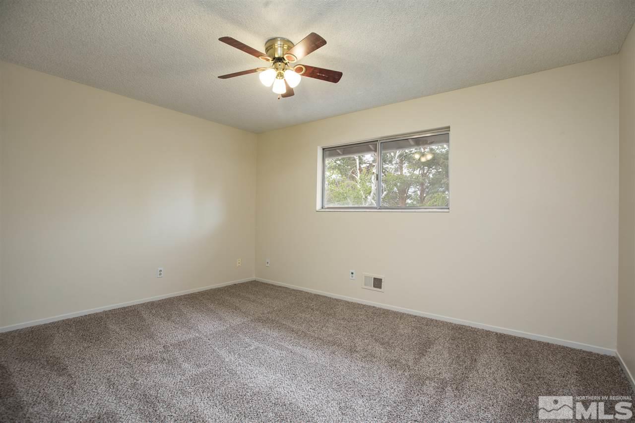 885 Twin Pines Road Reno, NV 89509 - Photo 17 of 25 an empty room with a chandelier fan and windows